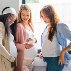 multicultural joyful pregnant women using smartphone